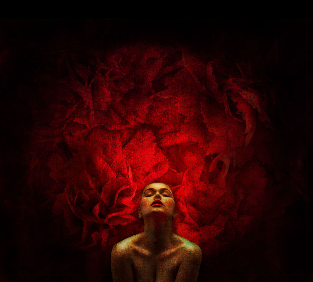 A woman sits against a vibrant red background, exuding confidence and poise.